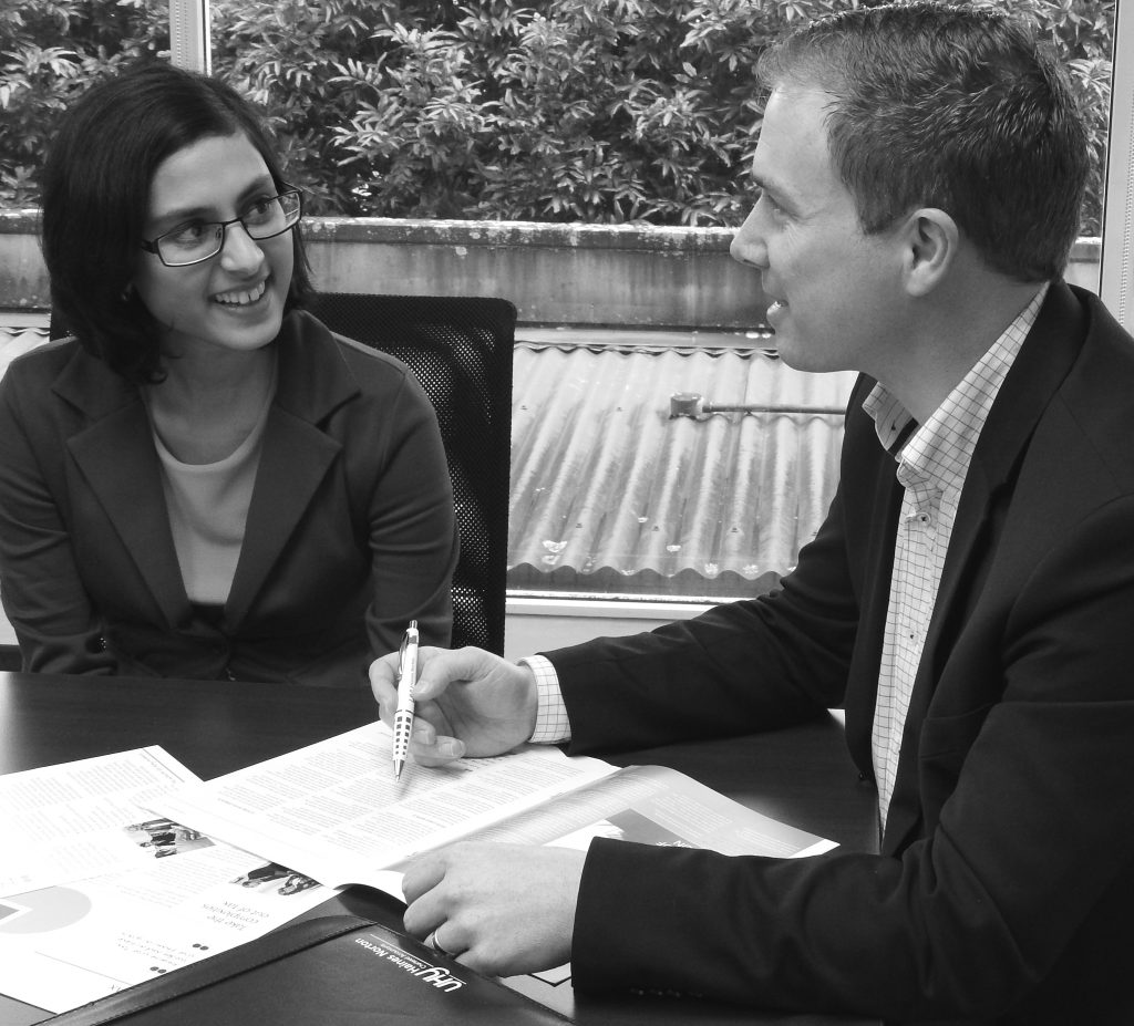 Two Auckland Chartered Accountants sitting at a table providing accounting services