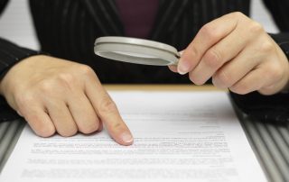 buying a business, looking at contract with magnifying glass